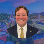 Headshot of Vermont Treasurer Mike Pieciak with a picture of Montpelier in the background