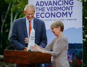 Tom Dee being handed the Citizen of the Year award by Kathleen Fisher, chair of the Southwestern Vermont Medical Center. The award is a marble statue shaped like the Bennington Battle Monument.